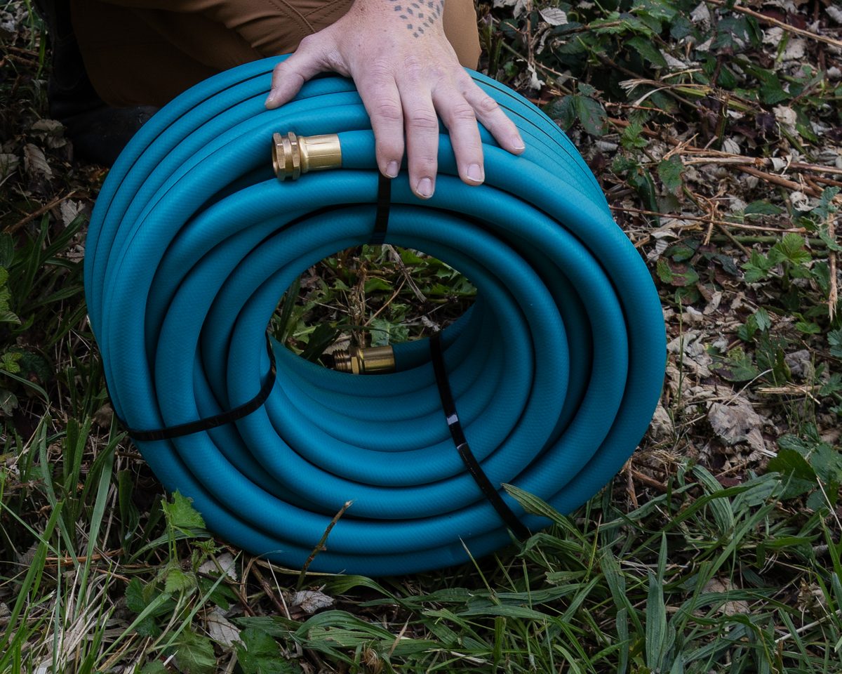 THE HOSE 3/4-inch banded coil on the grass, brass ends out