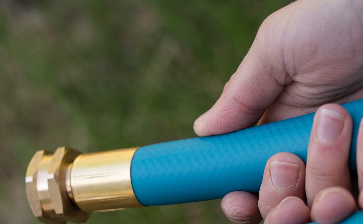 THE HOSE 3/4-inch in hand — woven jacket and solid brass coupling up close
